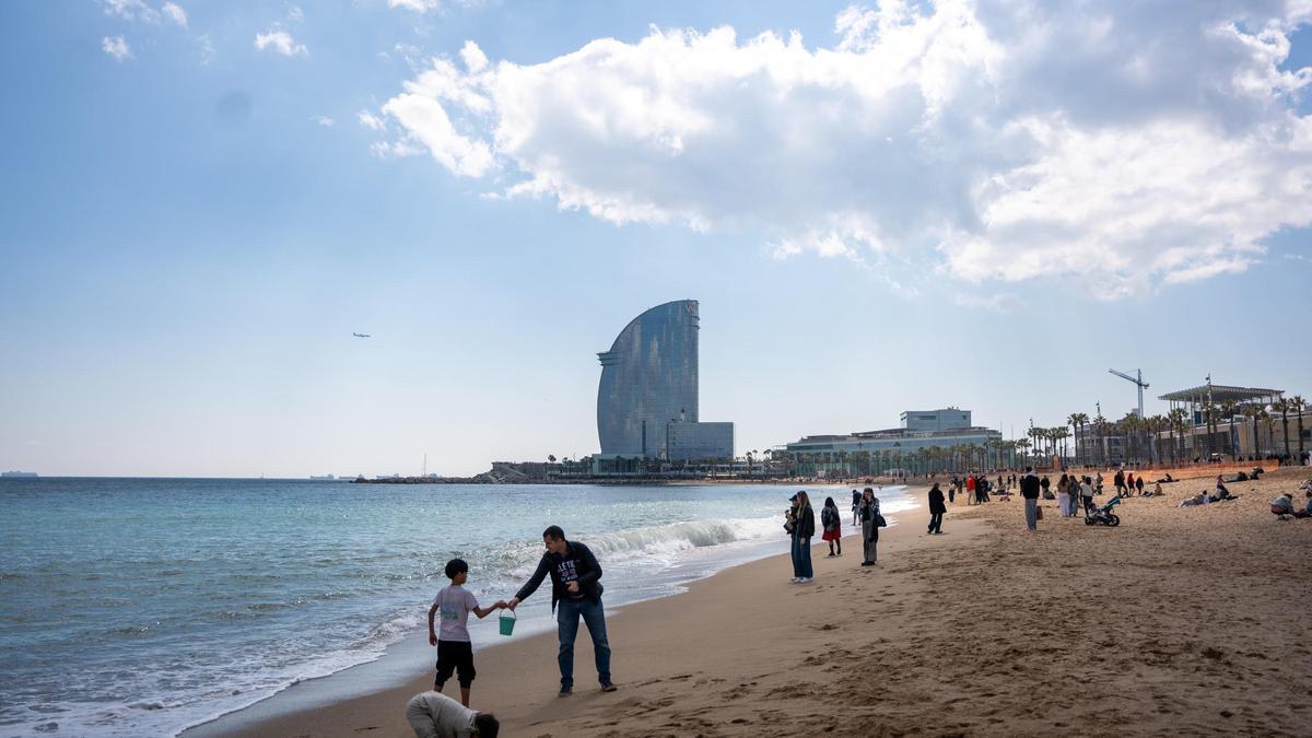 La playa de la Barceloneta con claros en el cielo
